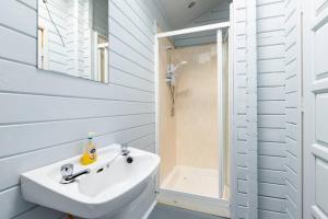a white bathroom with a sink and a shower at Rock Lodge in Kenmare +29 photos