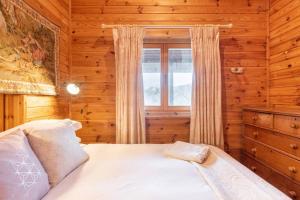 a bedroom with a bed and a window in a log cabin at Rock Lodge in Kenmare
