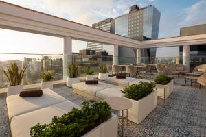 a rooftop patio with tables and chairs on a building at Casa Andina Premium San Isidro in Lima