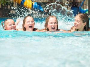 three girls playing in the water in a pool at Motueka Apartment in Motueka
