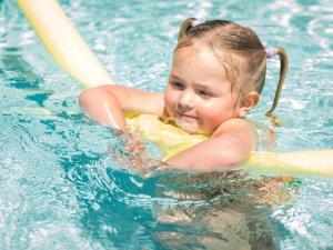 a young girl swimming in a swimming pool at Motueka Apartment in Motueka