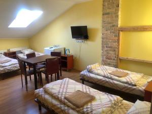 a room with two beds and a table and chairs at Hotel Sabina in Riga +49 photos