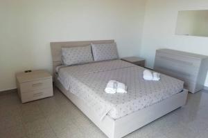 una camera da letto con un letto con due scarpe bianche di La casa al mare Corallo Bianco a Montegiordano