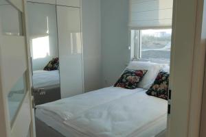 Habitación pequeña con cama y espejo. en Apartament Soft 16 en Biała Podlaska