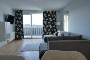 uma sala de estar com um sofá e uma grande janela em Apartament Soft 16 em Biała Podlaska