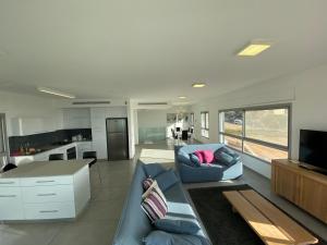 a living room with a blue couch and a kitchen at SeaScape Terraces Netanya in Netanya