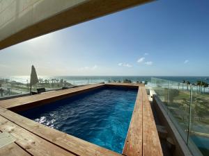 a swimming pool with a view of the ocean at SeaScape Terraces Netanya in Netanya