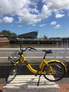 un vélo jaune garé sur le côté d'une rue dans l'établissement Hull Trinity Backpackers, à Hull