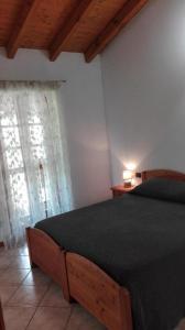 a bedroom with a bed with a black comforter and a window at Agriturismo Pastorelli in Osmate Lentate