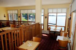 a restaurant with tables and chairs and a balcony at Rocky Crest Golf Resort in MacTier