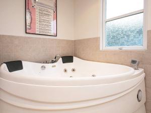 a white bath tub in a bathroom with a window at 6 person holiday home in Hals in Hals