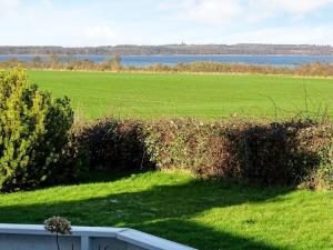 a view of a field and water from a house at 6 person holiday home in Svendborg in Svendborg