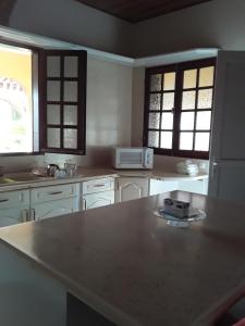 a kitchen with white cabinets and a counter top at Villa Grandes pièces in Petit-Bourg