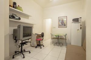 Apartamento Posto 6 في ريو دي جانيرو: غرفة معيشة فيها تلفزيون وطاولة وكراسي