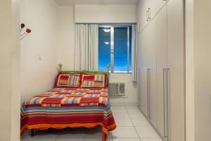 um pequeno quarto com uma cama e uma janela em Apartamento Posto 6 no Rio de Janeiro