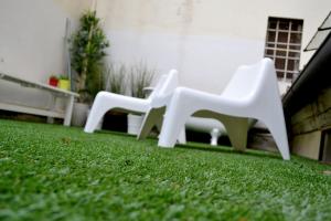 two white plastic chairs sitting on a lawn at Green Domus in Florence