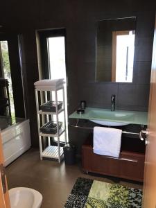 uma casa de banho com um lavatório e um balcão com um espelho em Luxus Ferienhaus Casa Paraiso em Sesimbra