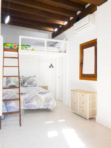 1 dormitorio con litera y escalera en Pasaje de Amores en Sevilla