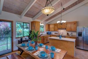 a large kitchen with wooden cabinets and a wooden table at Hamakua Pukana La Hale home in Papaaloa