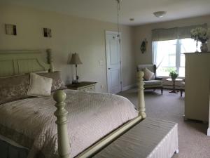 a bedroom with a bed and a chair and a window at Large Modern Private Suite by the Sea- Birders Paradise in Little Compton