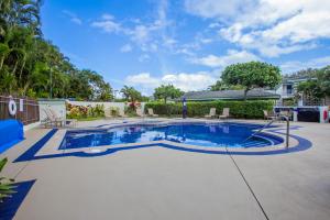 a swimming pool in a yard with chairs and trees at Hale Emmalani #311 condo in Princeville