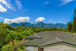 a house with a roof with mountains in the background at Villas of Kamalii 43 condo in Princeville