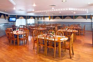 a dining room with wooden tables and chairs at Landmark Plaza Hotel in Dubai