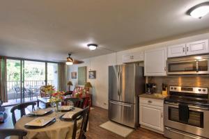 a kitchen with a dining table and a refrigerator at Maluhia Kahakai condo in Hilo