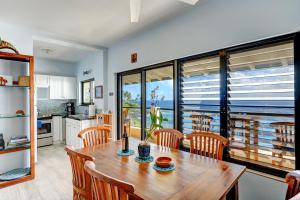 a kitchen and dining room with a wooden table and chairs at Poipu Shores 301B condo in Koloa