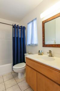 a bathroom with a toilet and a sink and a mirror at Malu Kauai, a Beautiful Kauai Cottage 1 Mile from Kalapaki Beach home in Lihue
