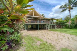 a house on the beach with a palm tree at Hale Hoku home in Hanalei