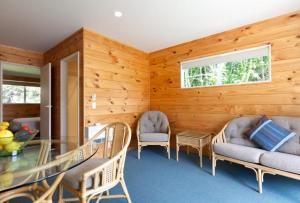 ein Wohnzimmer mit einem Glastisch und Stühlen in der Unterkunft Pauanui Pines Motor Lodge in Pauanui