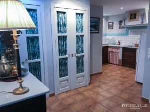 a kitchen with french doors and a table with a lamp at Los patios “ El Carmen” in Córdoba