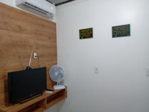sala de estar con TV y ventilador en Imóveis Por Temporada em Santarém no Pará en Santarém