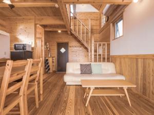 a living room with a white couch and a table at TIDA Resort Yakushima 旧 屋久島海の胡汀路てぃーだ in Yakushima