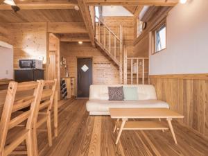 Una sala de estar con un sofá blanco y una mesa. en TIDA Resort Yakushima 旧 屋久島海の胡汀路てぃーだ, en Yakushima