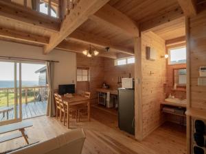 Una cocina y una sala con una mesa y un comedor. en TIDA Resort Yakushima 旧 屋久島海の胡汀路てぃーだ, en Yakushima