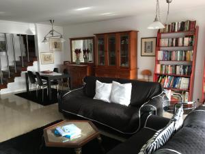 uma sala de estar com um sofá preto e uma mesa em Home2Home Lisbon em Lisboa
