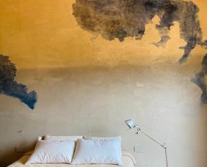Agriturismo PURO في بارغا: غرفة نوم مع أريكة و لوحة على الحائط