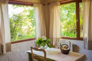 een tafel met een vaas met bloemen en een raam bij GOLF - Casa de huéspedes in Tandil