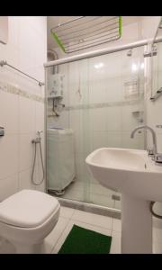 Apartamento Posto 6 في ريو دي جانيرو: حمام ابيض مع مرحاض ومغسلة