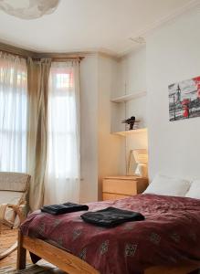 ein Schlafzimmer mit einem Bett mit einer roten Decke in der Unterkunft Home In Queen's Park in London