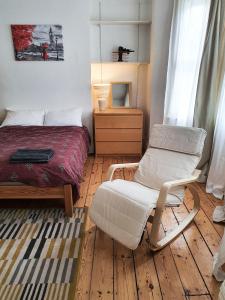 a bedroom with a bed and a chair at Home In Queen's Park in London