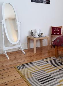 - un salon avec un miroir et une table dans l'établissement Home In Queen's Park, à Londres
