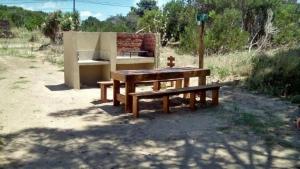 una mesa de picnic y un banco en un campo en Cristales De Agua en Mar de las Pampas