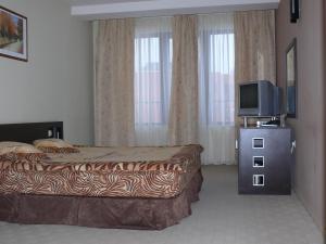 a hotel room with a bed and a tv at Hotel Brilliantin in Sliven