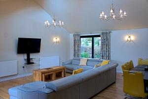 a living room with a couch and a tv at Hillside Lodge, Tor Farm in Cheddar