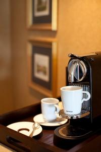 a coffee maker and two cups on a table at Wedgewood Hotel & Spa - Relais & Chateaux in Vancouver