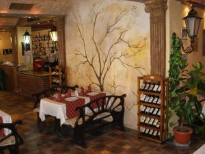 a dining room with a tree mural on the wall at Hotel Brilliantin in Sliven
