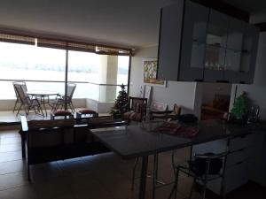 cocina y sala de estar con mesa y sillas en Departamentos Costa Pingueral, en Tomé